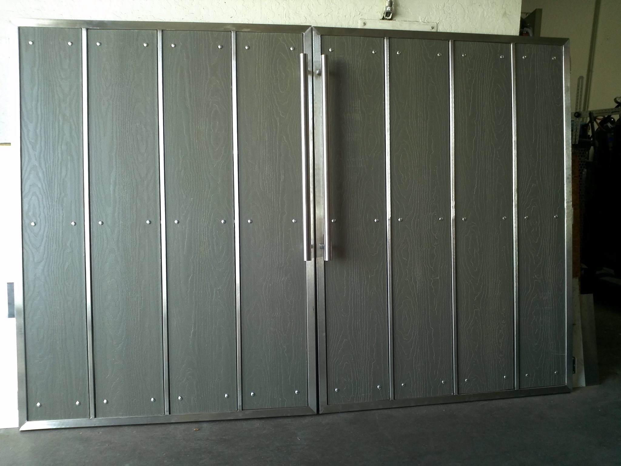 Custom metal-framed gate and door with composite panels